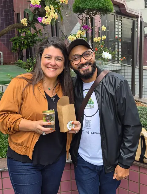 Ivan com uma cliente que segura o mini terrário recém-entregue